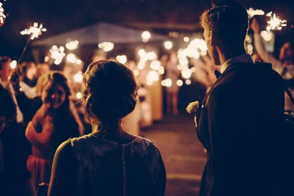 Guests holding lit sparklers in the evening