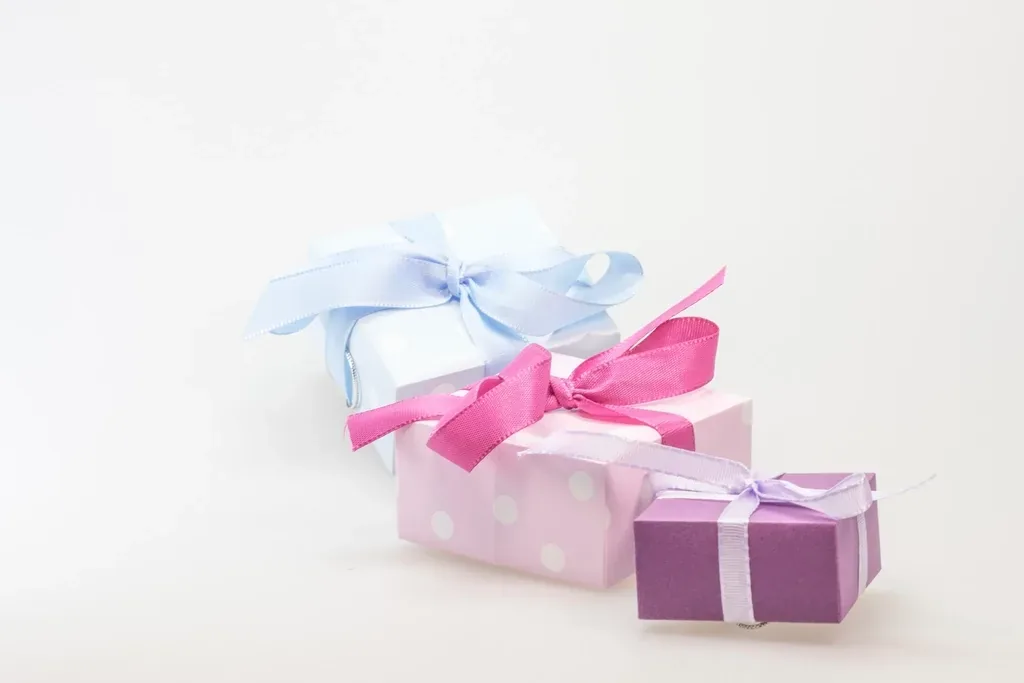 Three small gift boxes tied with pink and purple ribbons