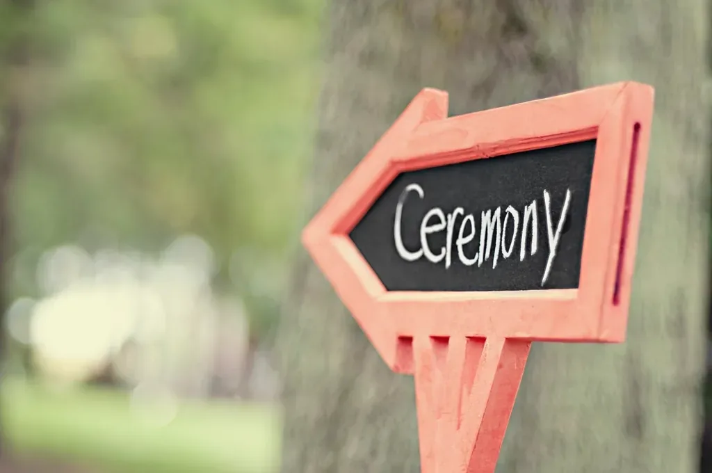 A wooden sign pointing towards the wedding ceremony