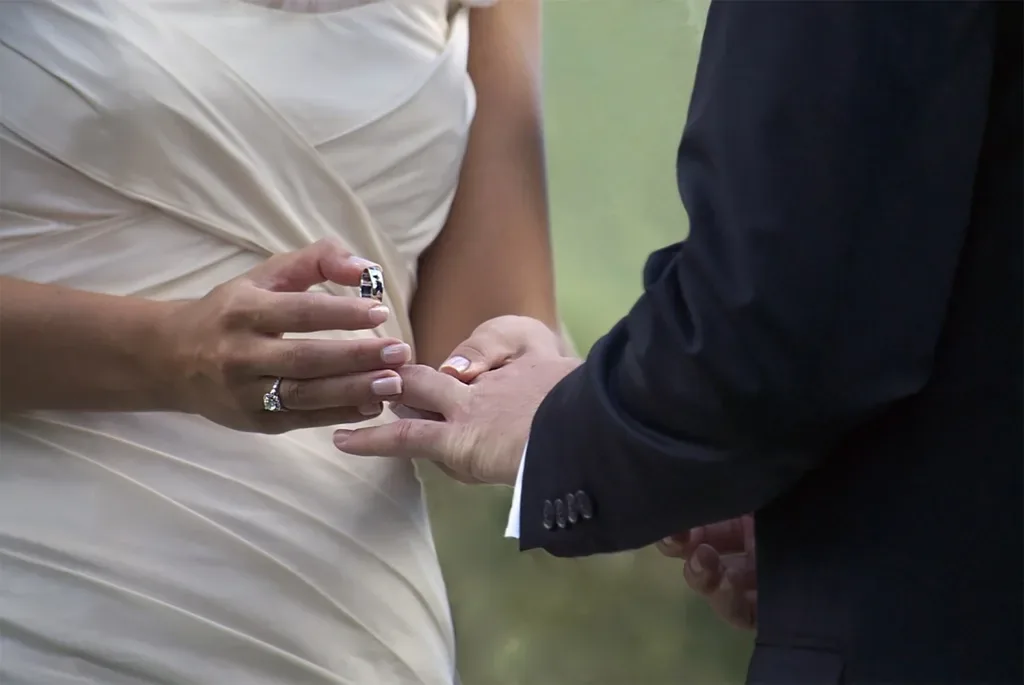 The groom placing a wedding ring on the bride's finger during the ceremony